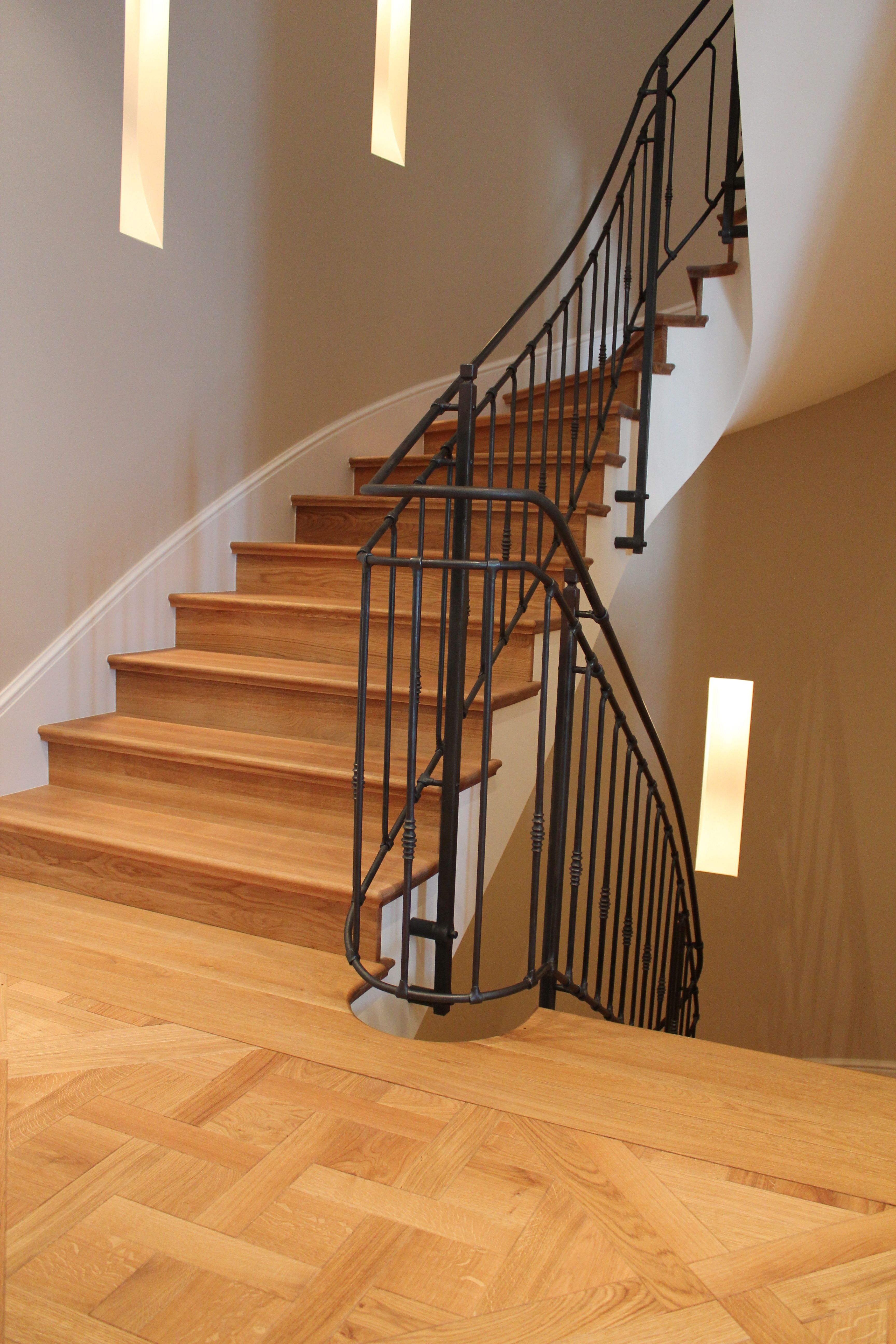 Ručně kované zábradlí v moderním interiéru z přírodních materiálů